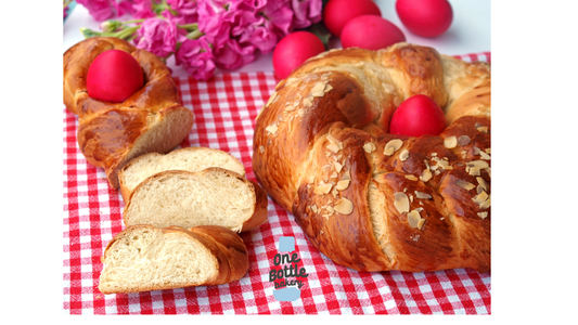 Greek tsoureki braided bread served on table, Easter sweet bread with red easter eggs.
