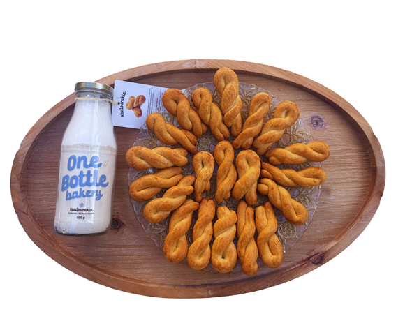 One Bottle Bakery European baking mixes in Canada featuring Koulourakia cookieswith finished baked desserts displayed beside glass bottle mixes