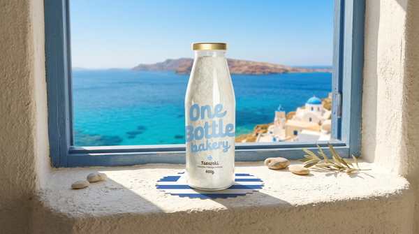 One Bottle Bakery tsoureki baking mix bottle inspired by traditional Greek Easter sweet bread with Greek islands view