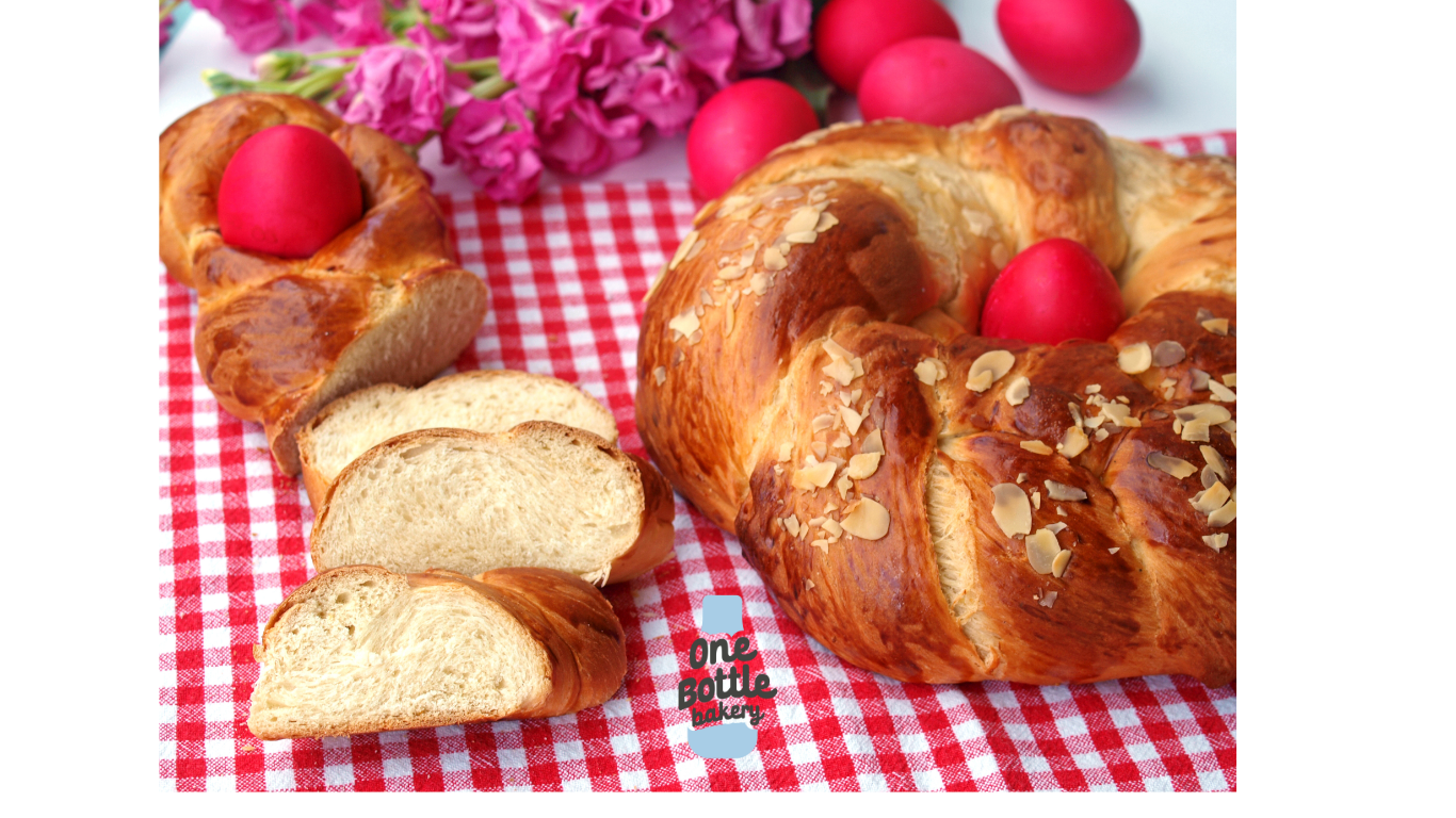 Greek tsoureki braided bread served on table, Easter sweet bread with red easter eggs.